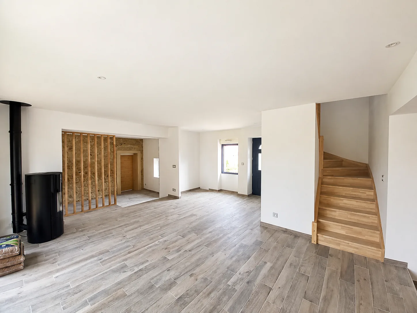 Salon avec poêle et escalier bois, après travaux