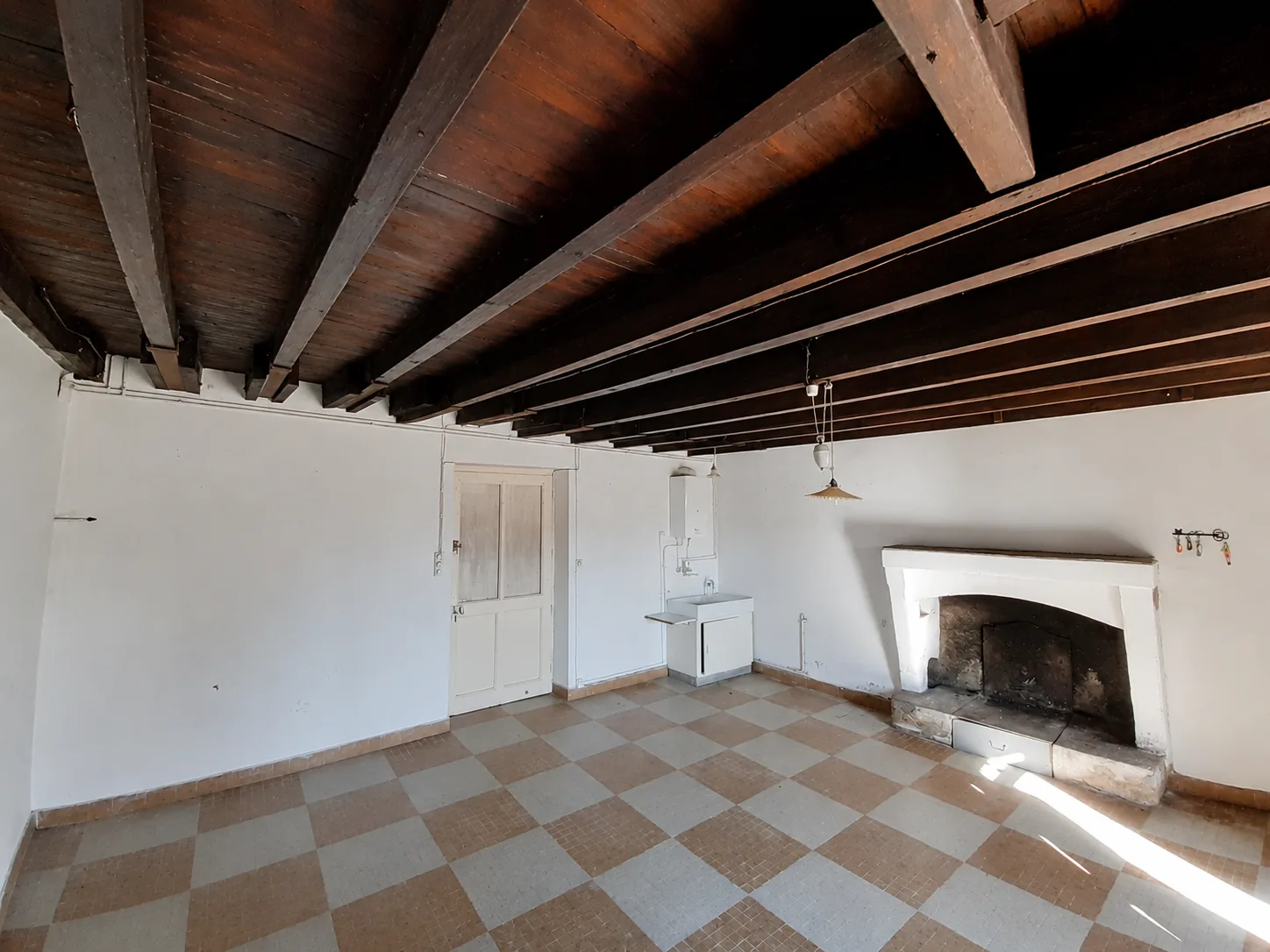 Pièce avec cheminée et carrelage en damier, avant travaux