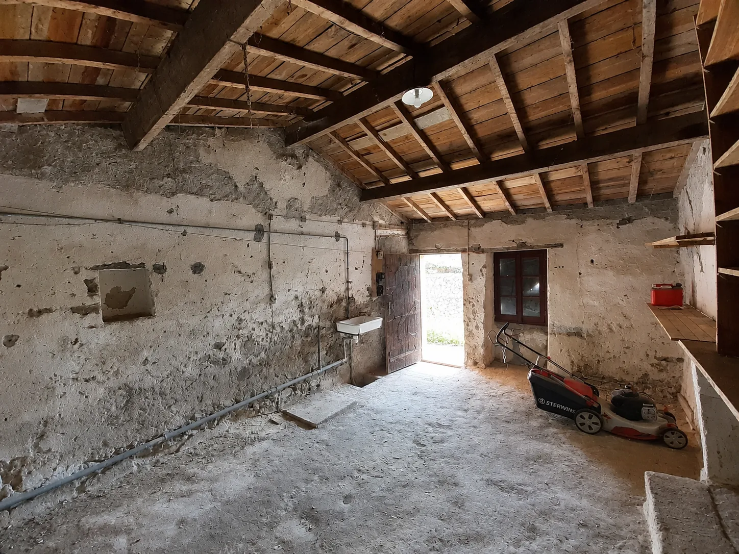 Ancienne pièce de la ferme sous charpente, sol brut, avant travaux